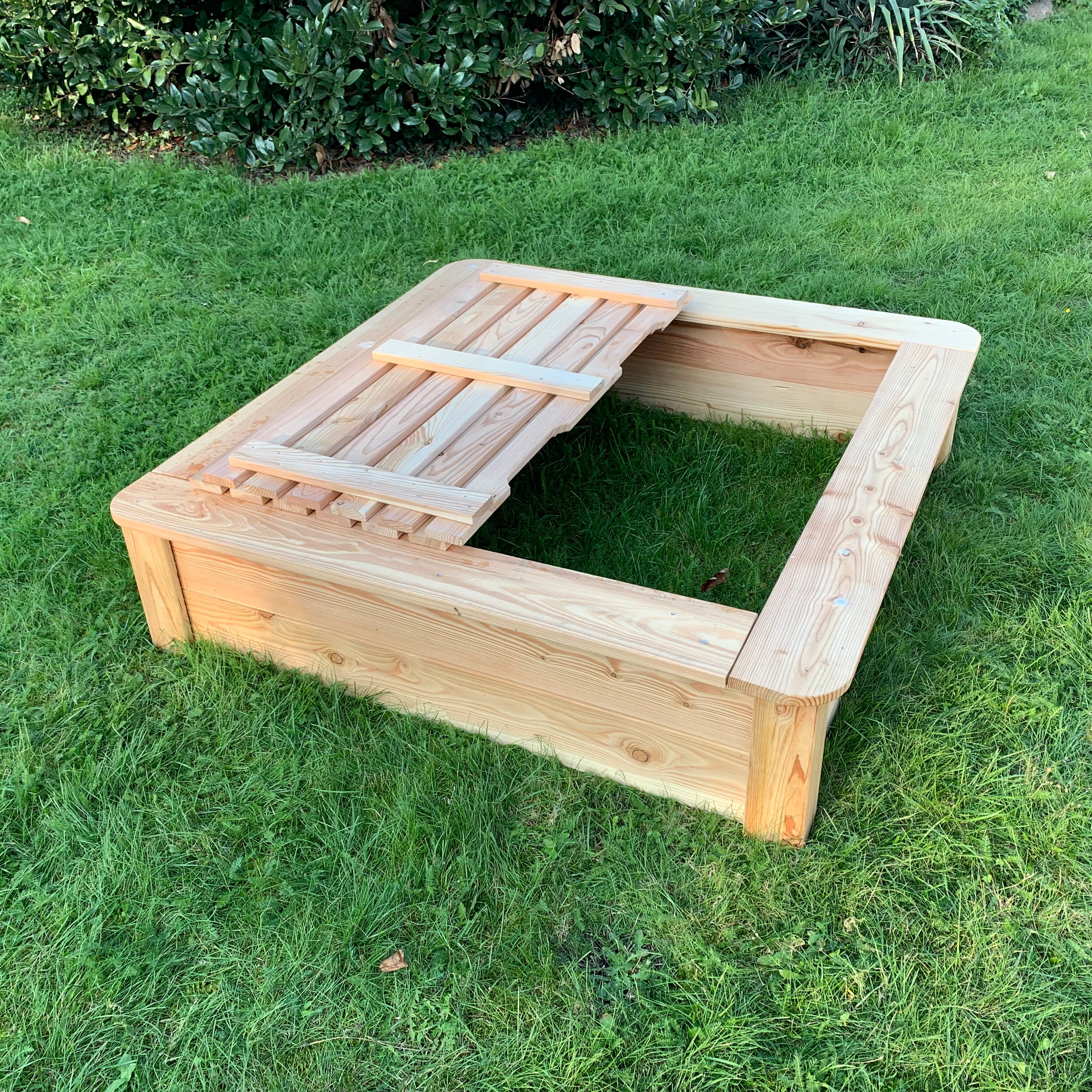 Ansicht Sandkasten mit halb offenem Deckel