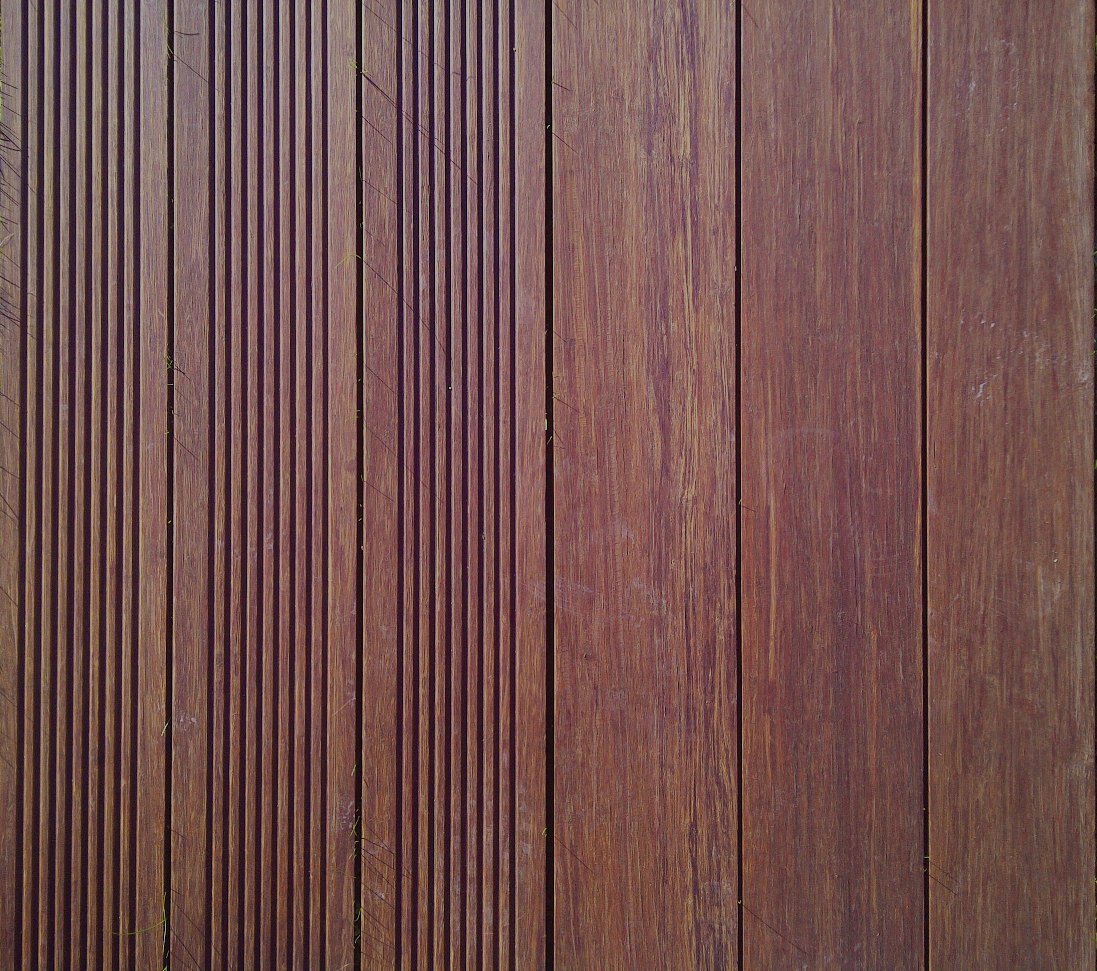 Nahaufnahme von Bamboo Xtreme Terrassendielen, links mit gerillter und rechts mit glatter, geölter Oberfläche, Farbe braun, Länge 1850 mm, Breite 137 mm, Stärke 20 mm, genutet, Density Thermo